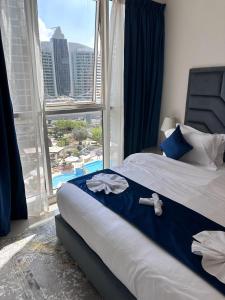 迪拜Dunya Tower Luxury and 2 min walk to Dubai Mall and Burj Khalifa的一间卧室设有一张床,享有游泳池的景色