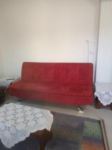 科扎尼Kipseli 1的客厅里一张红色的沙发,配有桌子