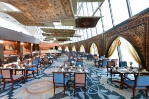 多哈多哈火炬酒店的用餐室设有桌椅和窗户。