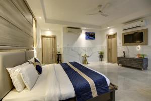 新德里Hotel Delhi 37 by Star Group NEAR DELHI AIRPORT的一间卧室配有一张大床和一台电视。