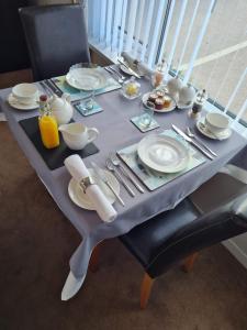 布里克瑟姆Brookside Guest House & Mini Spa的一张带盘子和餐具的灰色桌子
