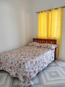 DaanbantayanGmL Lodge House的一间卧室配有一张带花卉床罩的床
