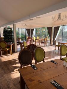 米尔登霍尔河滨公寓酒店的用餐室设有桌椅和窗户。