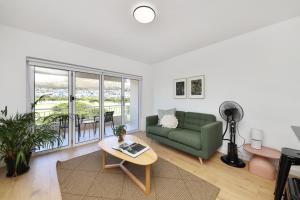开普敦穆耶点公寓 的客厅配有绿色沙发和桌子