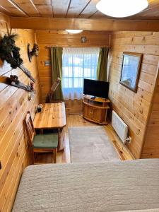 波罗维茨Alpine ski chalet Borovets with sauna的小屋内的房间,配有桌子和电视