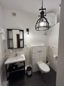 汉堡Ferienwohnung Bauernliebe 43 Citynah, urban Cowboystyle的浴室配有卫生间、水槽和灯