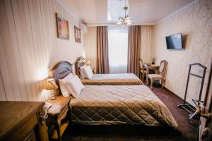 文尼察阿里斯托克拉酒店的酒店客房设有两张床和一张桌子。