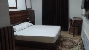 泰塔温hotel amilcar tataouine的卧室配有1张床、1张桌子和1把椅子