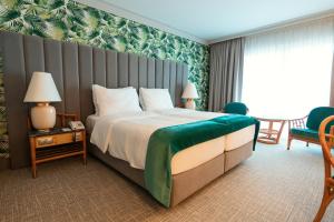 弗森多夫Eventhotel Pyramide的酒店客房带一张大床和一把椅子