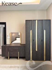 利雅德Kease Al-Mutamarat A-18 Timeless History AX96的一间卧室配有木制梳妆台和镜子
