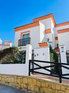 马贝拉Jolie maison à Cabopino Marbella的前面有黑色围栏的白色房子