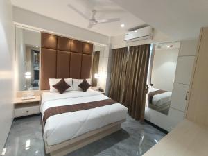 塞恩Hotel Pearl Residency的一间卧室设有一张大床和一个大镜子