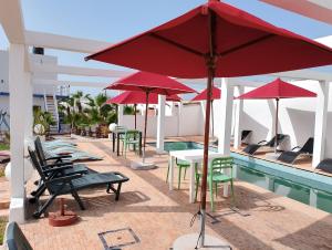 阿加迪尔Riad Ocean Beach Douira的一组桌子和遮阳伞,位于游泳池旁