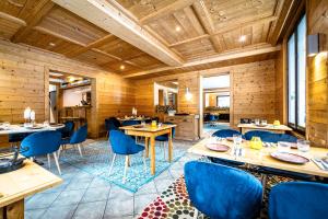 夏蒙尼-勃朗峰L'Arveyron Open House的餐厅拥有木墙和蓝色的桌椅