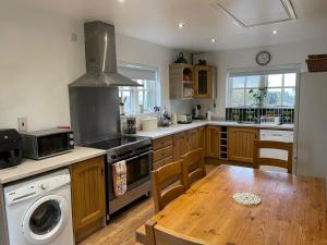 巴林托伊Dunnaglea Cottage, Ballintoy的厨房配有桌子和炉灶。 顶部烤箱