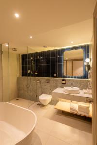 莫尔穆冈Regenta Place Vasco Goa的带浴缸、卫生间和盥洗盆的浴室