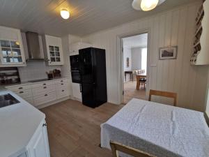 努尔菲尤尔埃德Sjarmerande hus i Eidsgata的厨房配有黑色冰箱和桌子