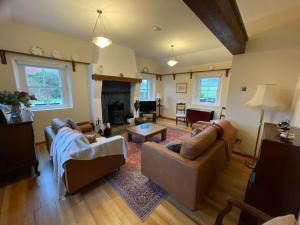 巴林托伊Dunnaglea Cottage, Ballintoy的客厅设有两张沙发和一个壁炉