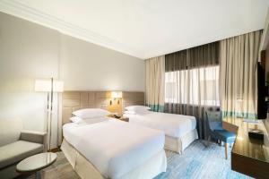 麦加Four Points by Sheraton Makkah Al Naseem的酒店客房,设有两张床和一张沙发