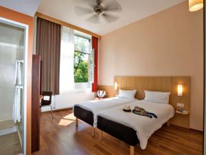 柏林ibis Berlin City Süd的一间卧室设有一张大床和一个窗户。