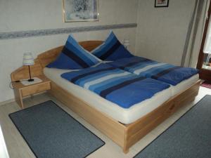 鲁波尔丁Ferienwohnung für 3 Personen in Ruhpolding, Bayern的一张床上有蓝色枕头的睡床