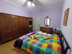 都灵HOTEL OFFRE THE BULL STADIUM的一间卧室配有一张色彩缤纷的床和镜子