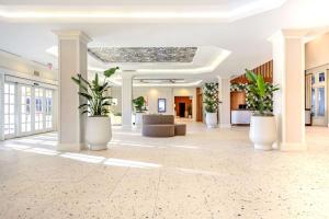 迪尔菲尔德海滩Embassy Suites by Hilton Deerfield Beach Resort & Spa的大堂,有植物,放入大白锅