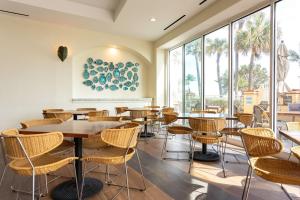 迪尔菲尔德海滩Embassy Suites by Hilton Deerfield Beach Resort & Spa的餐厅设有桌椅和大窗户。