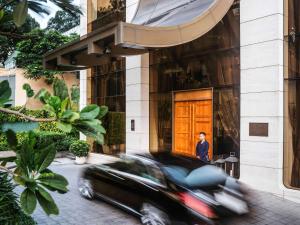 胡志明市西贡美憬阁艺术酒店的大楼前的一辆黑色汽车