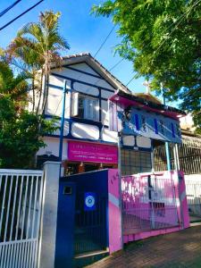 圣保罗Casa da Vila Hostel Guest House的粉红色和蓝色的房子,带门