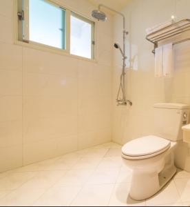 礁溪汤巢莎瓦迪卡民宿的白色的浴室设有卫生间和窗户。