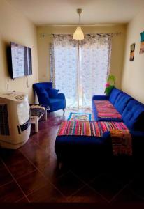 马特鲁港Porto Matroh New Chalets的客厅配有蓝色的沙发和电视