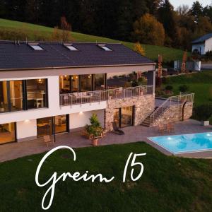 德意志兰茨贝格Greim15 --- ganzes Ferienhaus mit Fernsicht, Pool, Wellness的一座带游泳池和绿色字眼的大房子