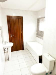 AsoCentral District Apartment (Abuja)的白色的浴室设有卫生间和水槽。
