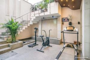 古尔冈Indiyaah Inn的大楼内带楼梯和健身器材的健身房