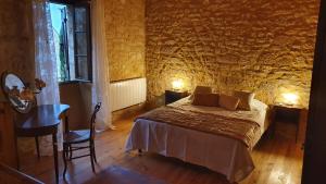 多姆Maison Domme Dordogne的一间卧室配有一张床、一张桌子和一个窗户。