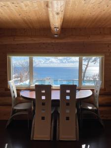 Topetsuゲストハウス風の丘的一间带桌椅和大窗户的用餐室