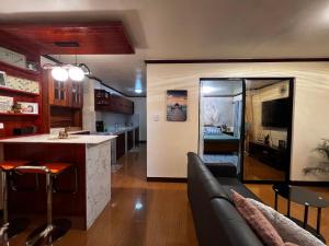 San Jose de BuenavistaJoymendz的厨房以及带沙发和台面的客厅。