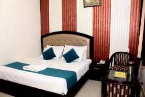 哈里瓦Hotel Anand的一间卧室配有一张带蓝色和白色枕头的床