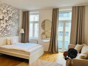 维也纳Zentrales Apartment mit Balkon的一间卧室配有一张床、一张沙发和一面镜子