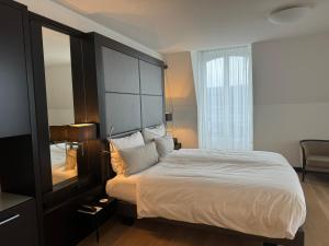 卢塞恩诺普尔卢塞恩酒店的一间卧室配有一张大床和大床头板