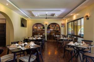 蒙巴萨Makaazi Nyali的一间带桌椅的餐厅和一间酒吧