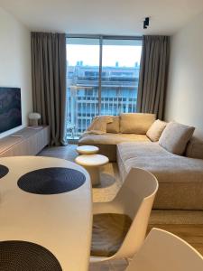 尼乌波特Luxe appartement `t Sant Nieuwpoort Bad的客厅配有沙发和桌子