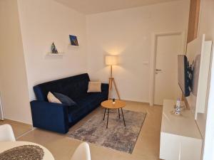 格拉达茨Apartment Ana - Gradac的客厅配有蓝色的沙发和桌子