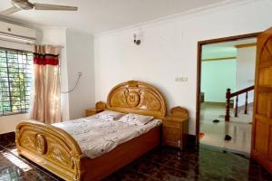 巴纳内拉斯Kumar Para Deluxe Villa的一间卧室配有木床和镜子