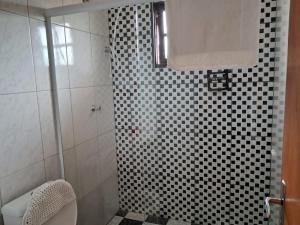 坎波斯杜若尔当Casa de Boneca的浴室配有黑白格子的淋浴间