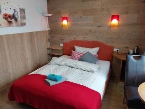SohlandLandhotel Waldschlößchen的一间卧室配有一张带红色毯子的床