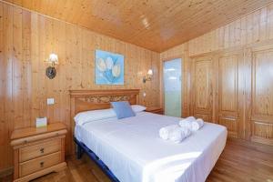 尼格兰Tranquilidad junto al mar by CABANA Rentals的卧室设有白色的床和木墙