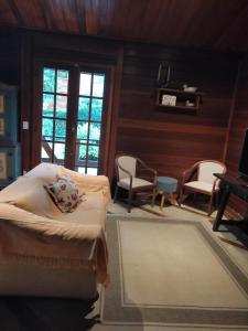 特雷索波利斯Paz na Serra Teresopolis的一间卧室配有床、椅子和钢琴