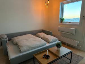伊卢利萨特Modern seaview house Ilulissat的一张位于带桌子和窗户的房间的床铺